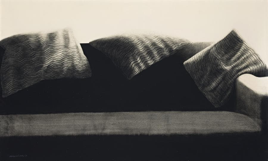 A SOFA WITH CUSHIONS ON TOP