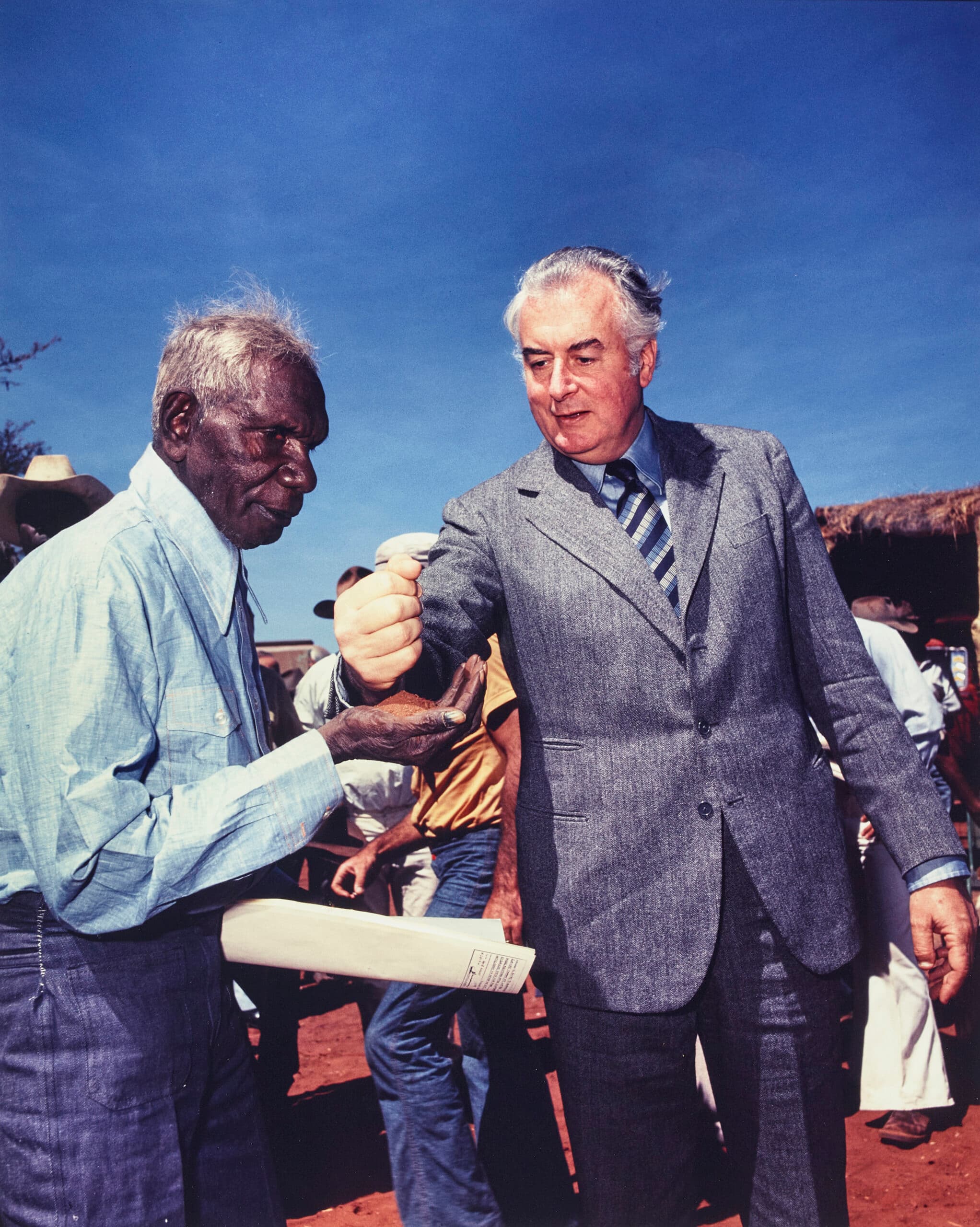 PRIME MINISTER GOUGH WHITLAM POURS SOIL INTO THE HANDS OF TRADITIONAL LANDOWNER VINCENT LINGIARI, NORTHERN TERRITORY